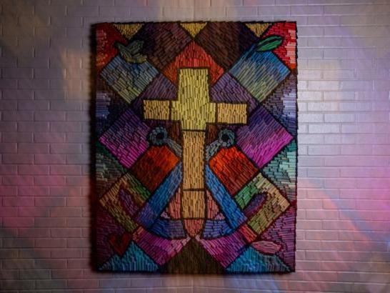 A piece of artwork depicting a cross, symbols of the Brothers of the Holy Cross, and colorful squares at The Holy Cross Institute.